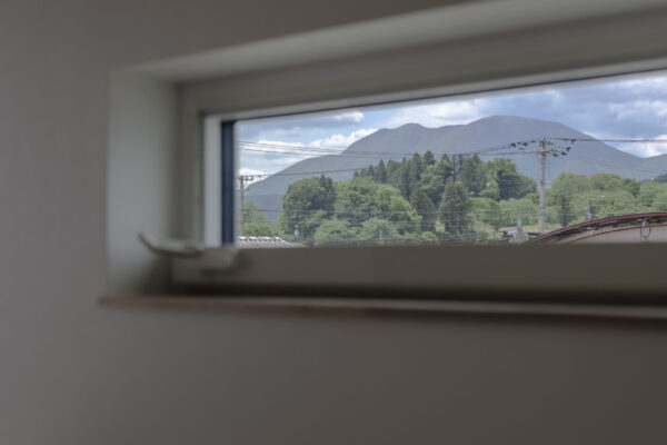 造作デスクから窓の先に広がる遠くの山の景色